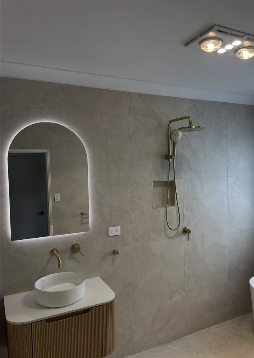 Bathroom fit-out — backlit arch mirror, brass tapware